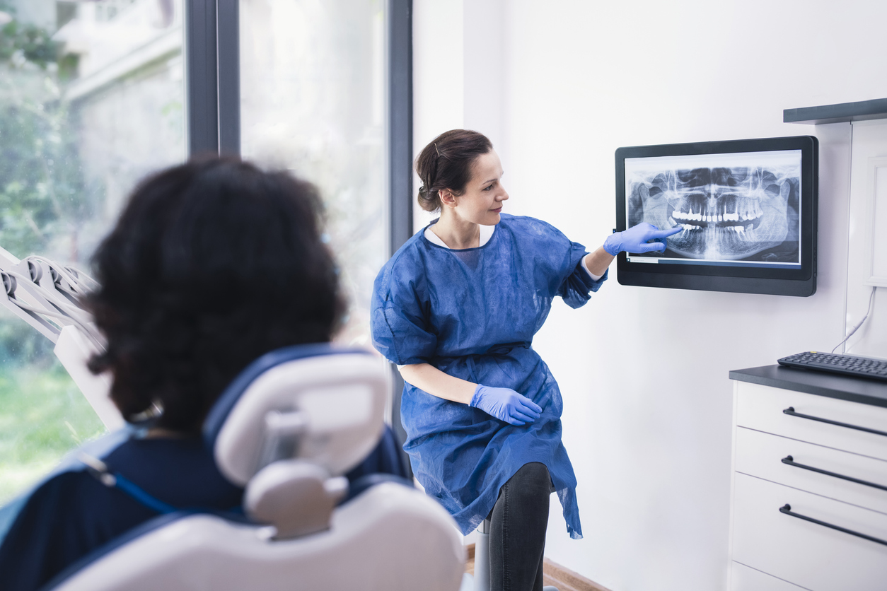 Dentist Explaining Tooth X-Rays To A Patient.